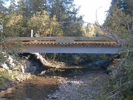 A steel stringer, wood deck bridge provides access for forest harvesting, without disturbing the stream channel. Photo: Forest Engineering Research Institute of Canada.