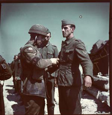 Picture showing a Canadian NCO "frisking" German captives, ca. June 1944.